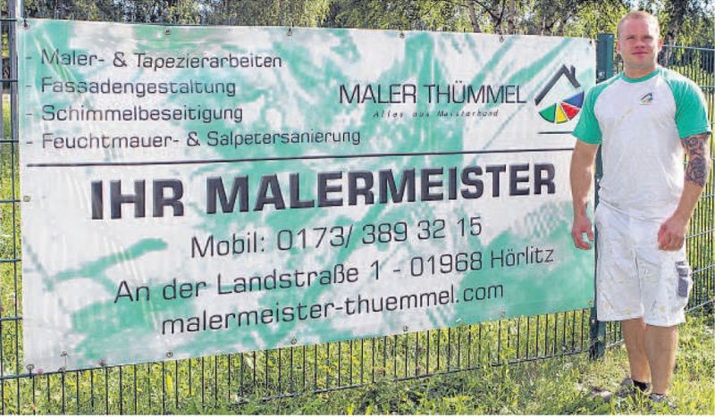 Malermeister Thümmel vor großen Werbebanner und Logo.